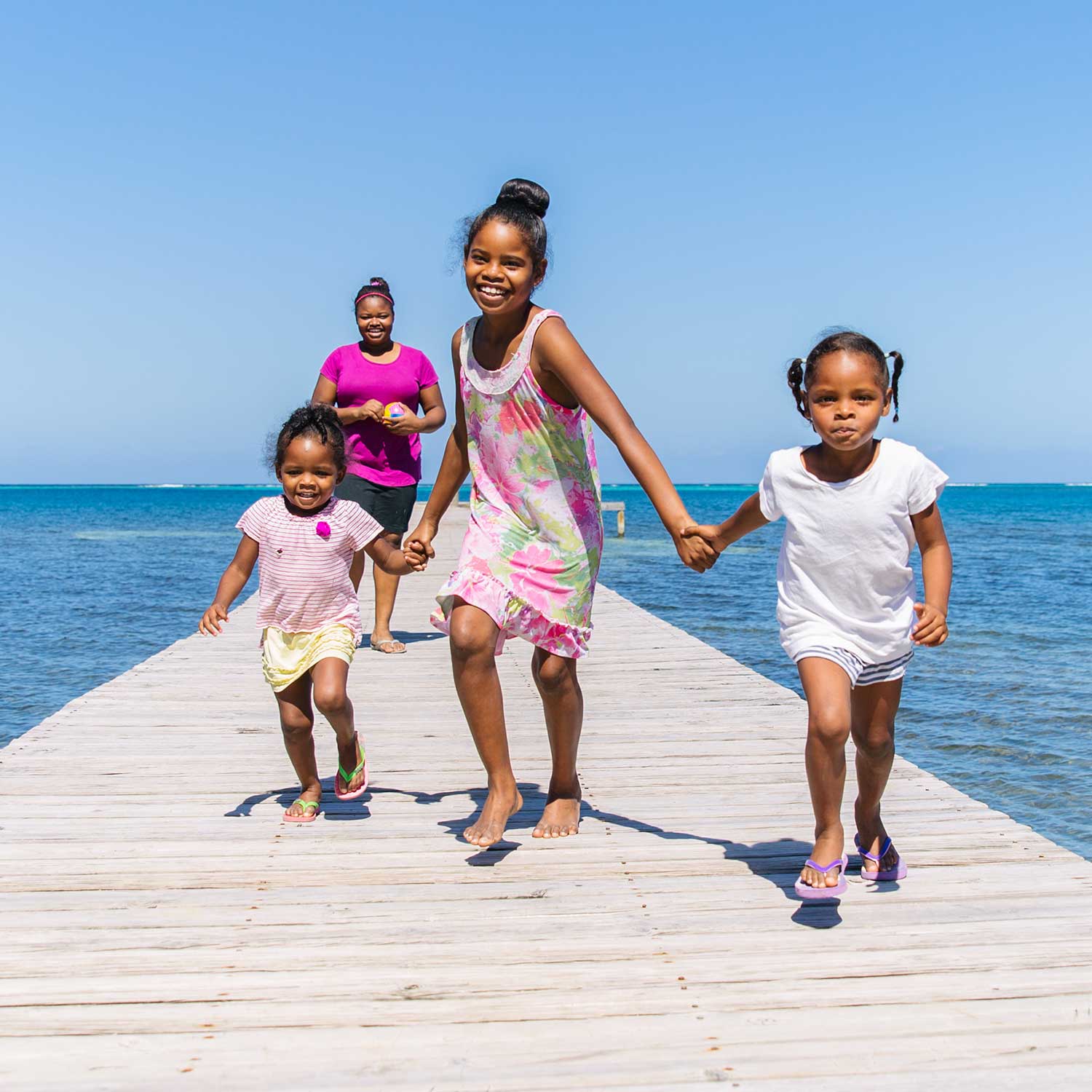 Family fo young girls running on a pier dock