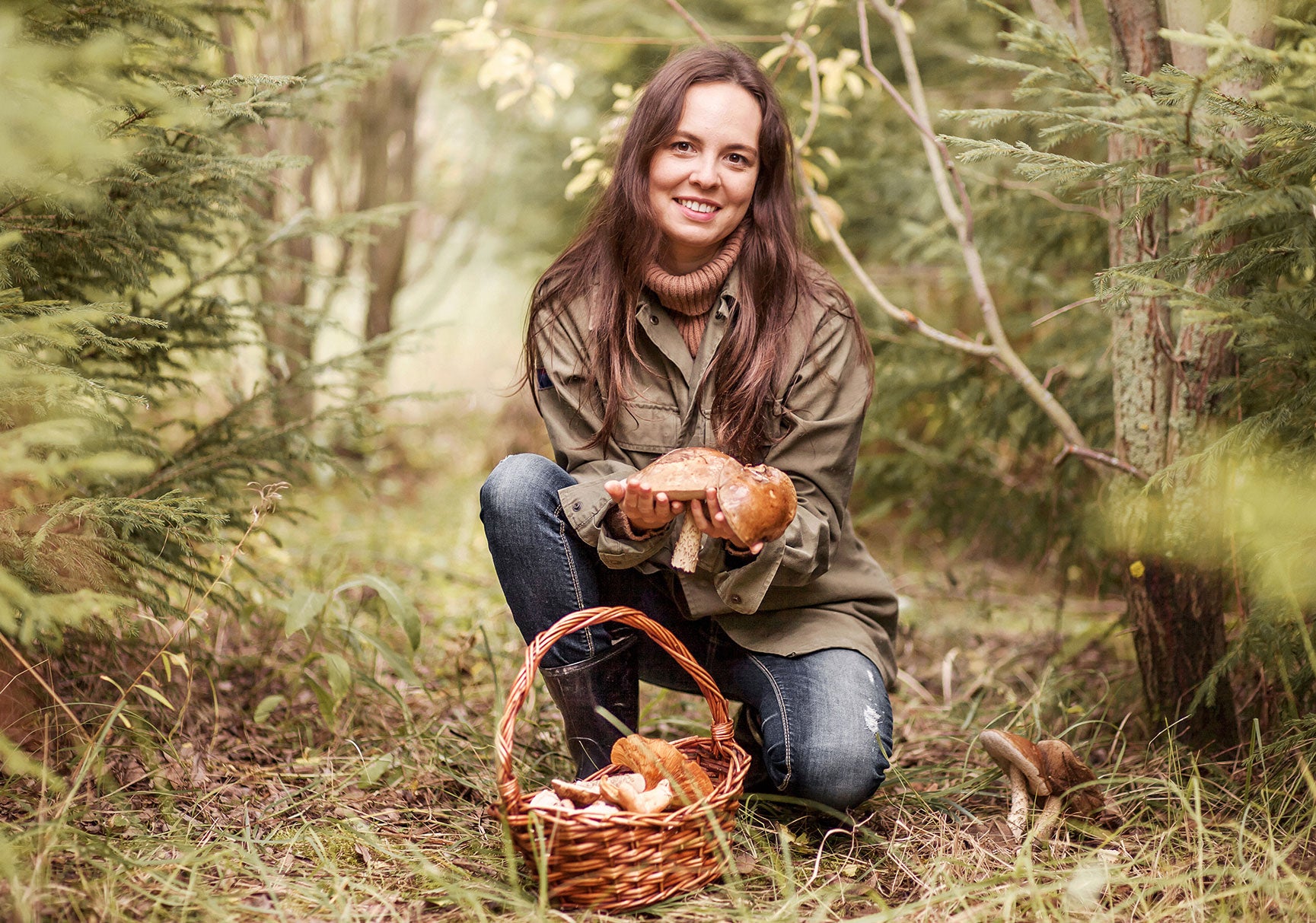 Young woman gathers mushrooms in the forest.