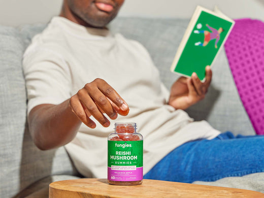 Man with reishi mushroom gummies on a desk reading