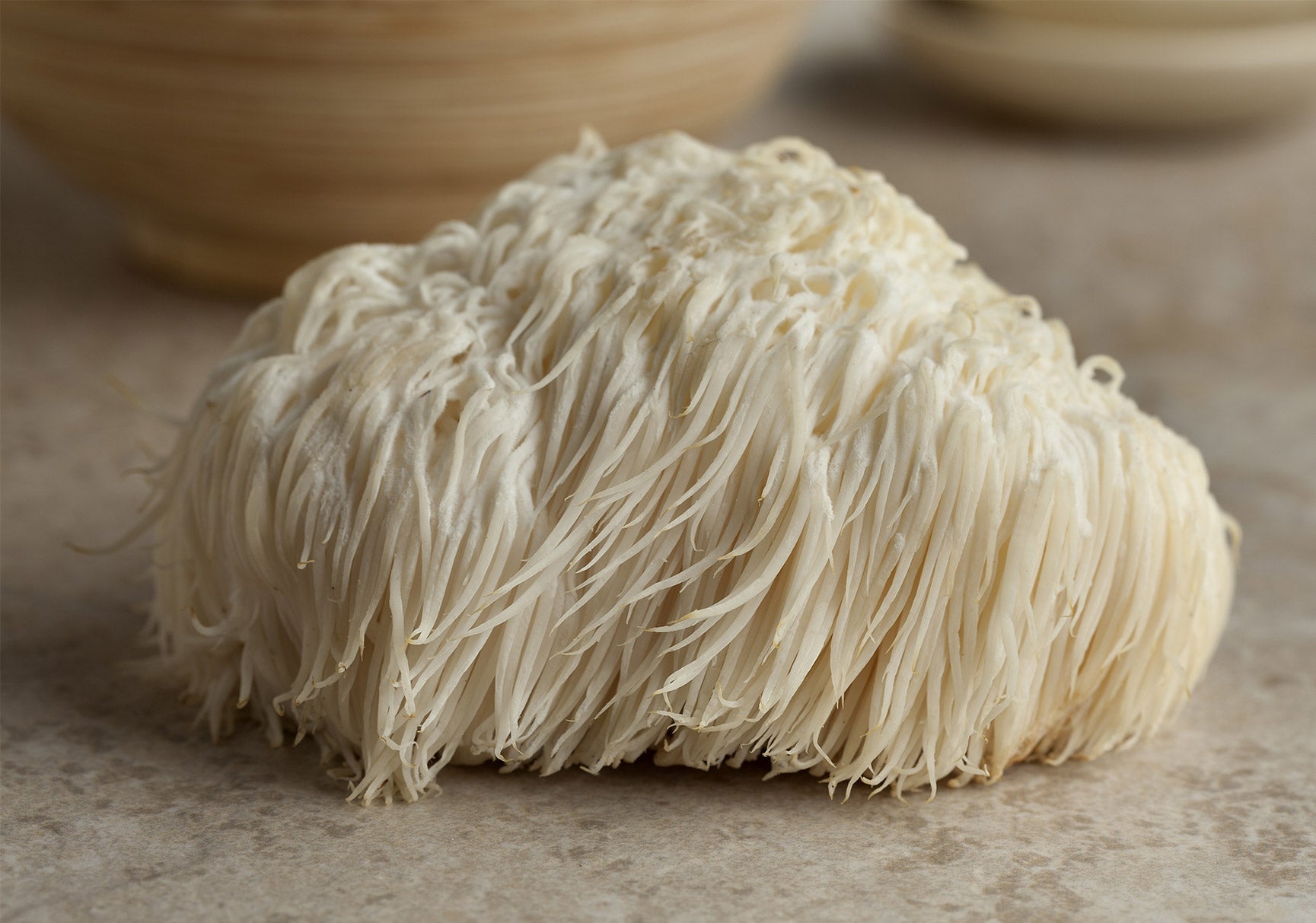 Close-up of a white mushroom on a counter, highlighting its natural texture in an indoor setting.