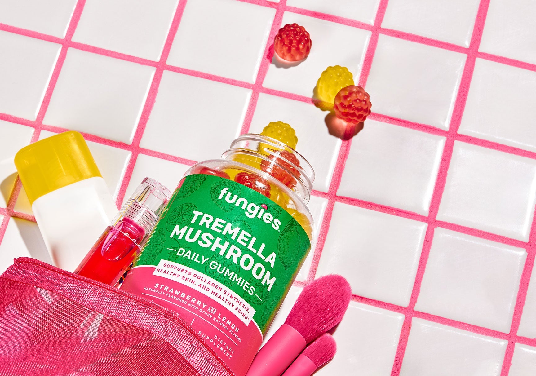 A bottle of gummy candies and a bag of makeup displayed on a tile surface, featuring close-ups of yellow and red candies.