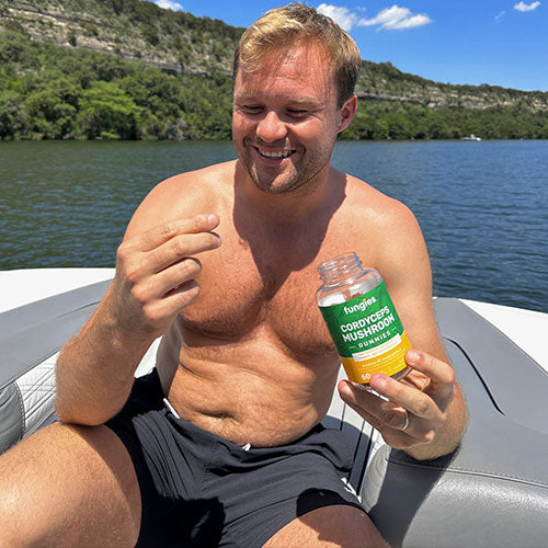 Guy on boat eating Fungies Cordyceps gummies