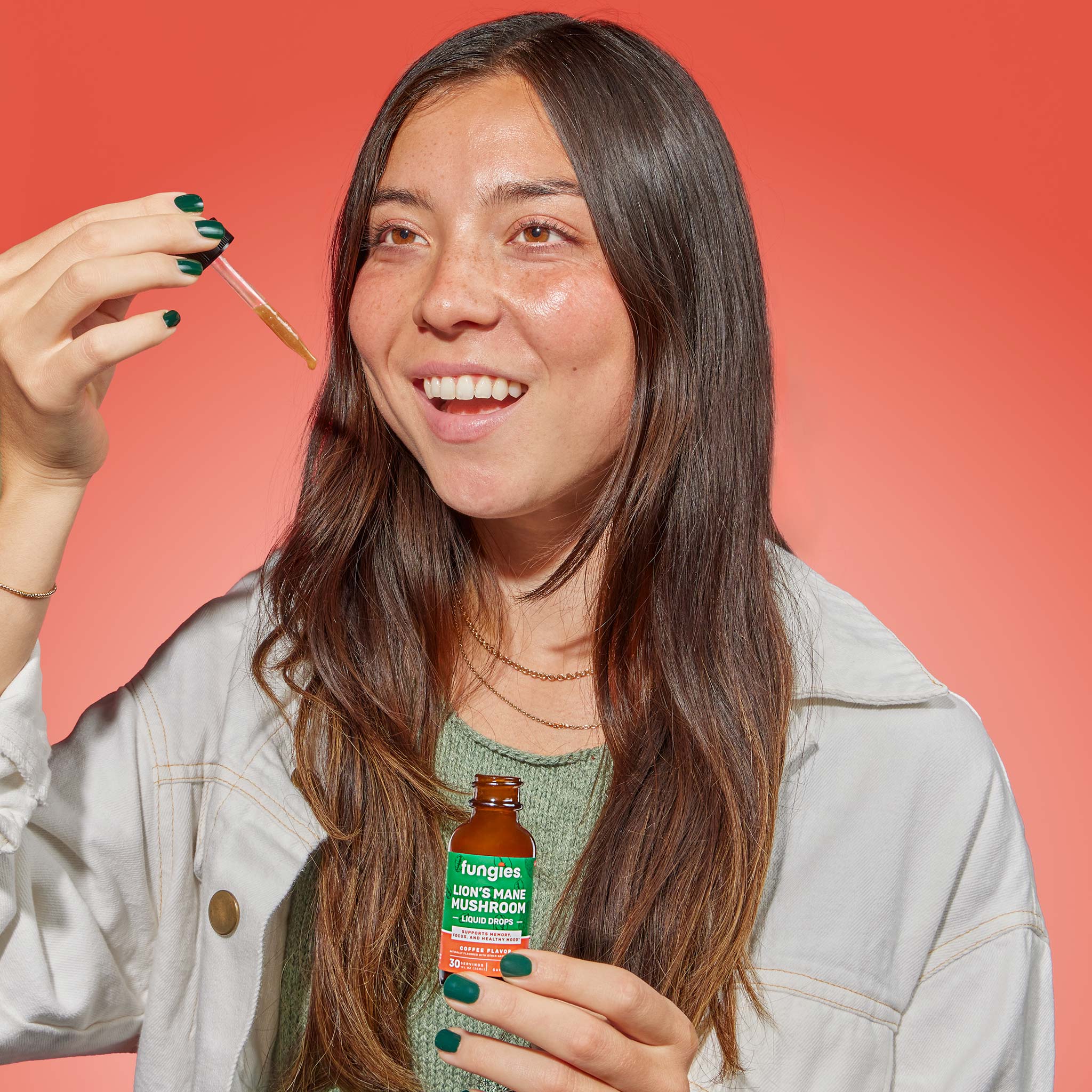 Woman holding Lion's Mane Mushroom Liquid Drops with dropper, promoting brain health, focus, and memory enhancement through organic mushroom extract.