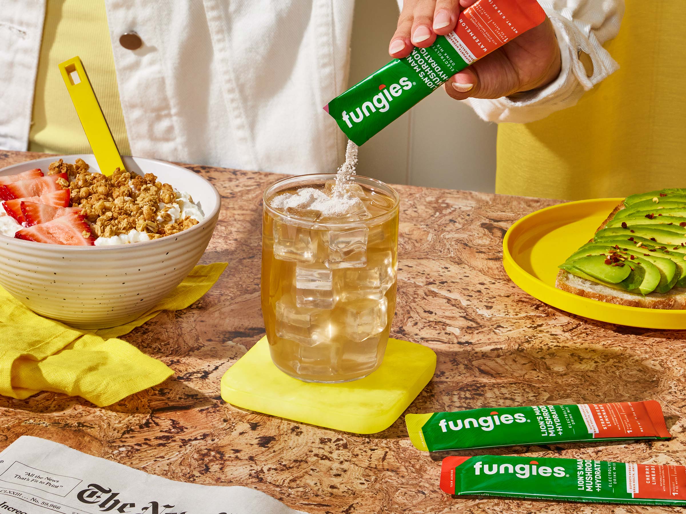 Woman using her Fungies hydration powder for a boost with her breakfast